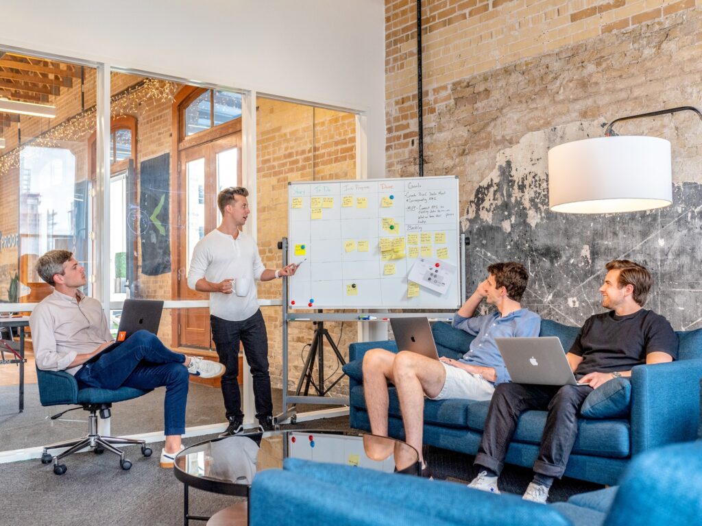 A modern product marketing team working in a modern office around a whiteboard